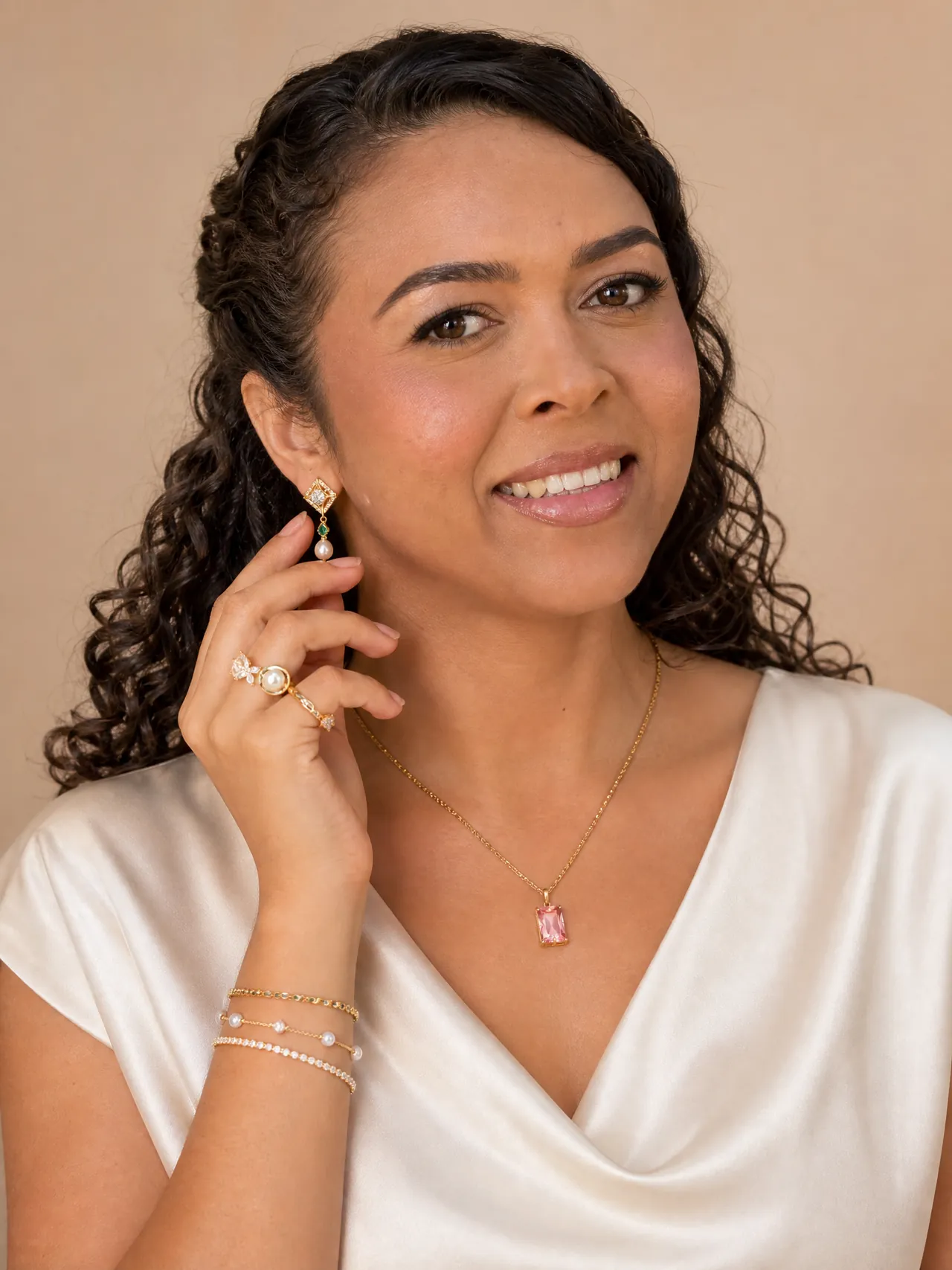 Jéssyka Araújo sorrindo, usando brincos, anéis, colar e pulseiras de semijoias.